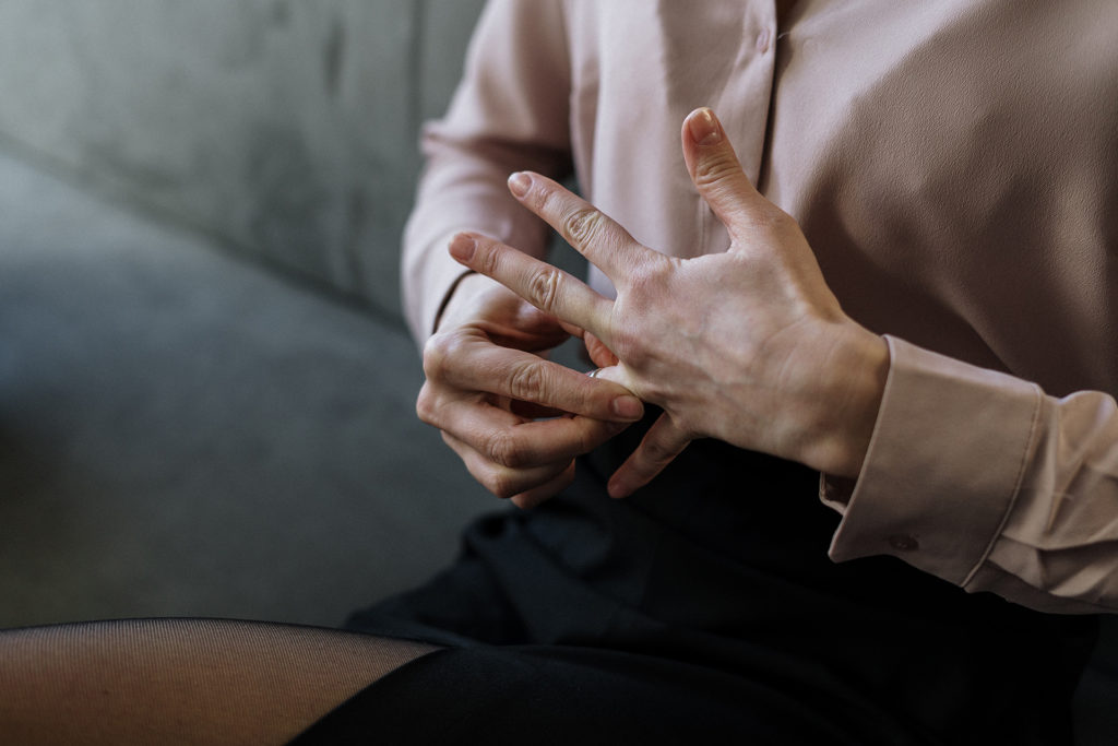 woman taking wedding band off finger