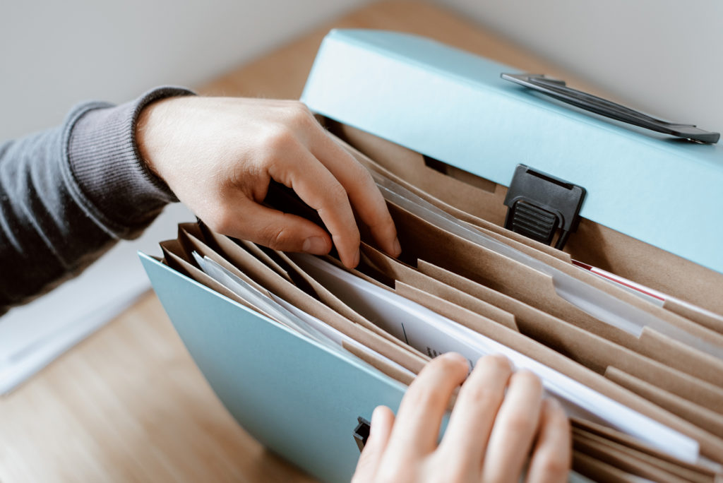 person looking through file folder